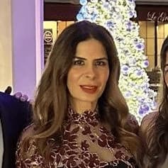Portrait of Ana Laura Melhem in front of a lit Christmas tree