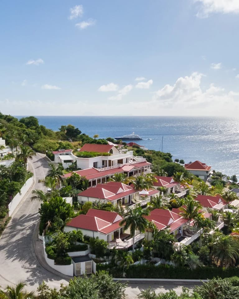 Red-roofed villas above a bay on a sunny day