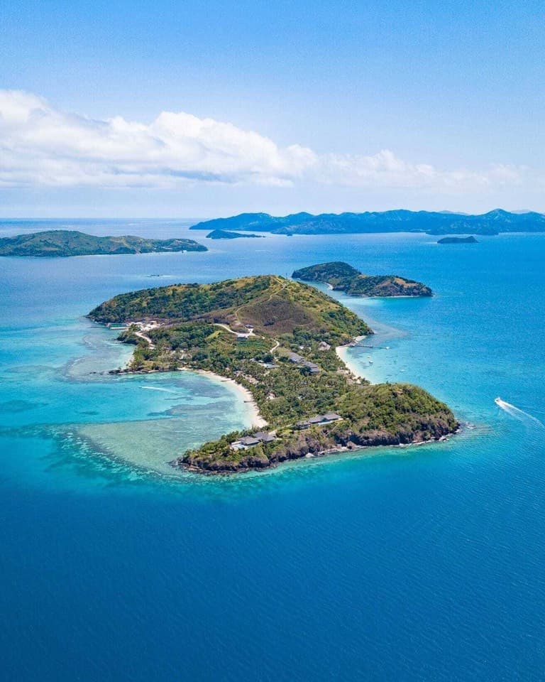 A green island ringed by turquoise water from above